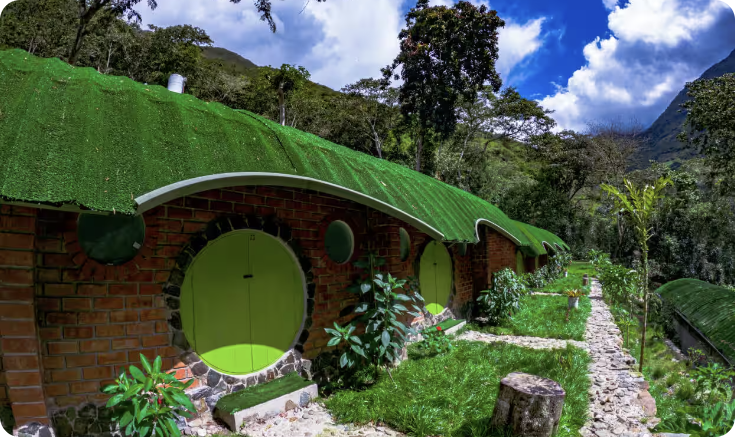 Row of hobbit-style houses with green round doors and grass roofs